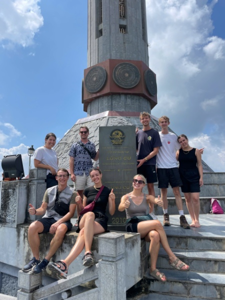 Tourists take photos at the foot of the flagpole